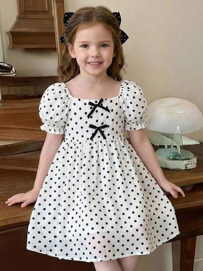 Robe à col carré, manches bouffantes et volants tressés pour jeune fille. Robe courte à manches courtes pour filles. Robe jeune fille crème et noire à pois avec nœud